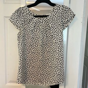 Black and white spotted blouse with short sleeves and zipper